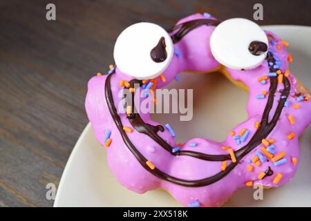 Purple Monster Halloween Doughnut Isolated on Black Wooden Background Stock Photo