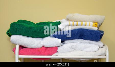 Horizontal close-up shot of multi-colored towels against a yellow background with copy space. Stock Photo