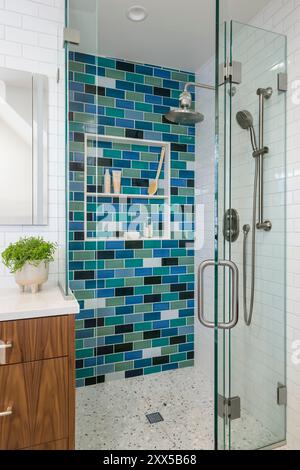 A bathroom with a blue green vanity cabinet, white marble countertop ...