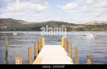 Lake Windermere with wooden jetty and boats on a sunny day in Lake District, Cumbria, UK Stock Photo