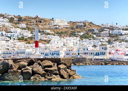 Mykonos, Greece - 7 May 2024: The town of Mykonos on the Greek island of the same name, known for its whitewashed houses and deep blue sea. View of a lighthouse in the town s old harbor *** Die Stadt Mykonos auf der gleichnamigen griechischen Insel, bekannt für ihre weiß getünchten Häuser und das tiefblaue Meer. Blick auf einen Leuchtturm im alten Hafen der Stadt Stock Photo
