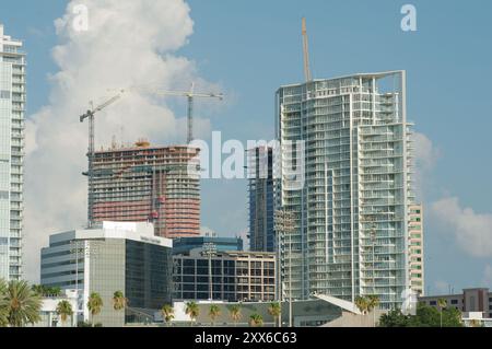 Wide shot Looking north from Demens Landing Park over bright blue water to St. Petersburg, Florida cityscape . Bright  blue and white sky. Green trees Stock Photo