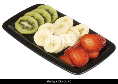 Close up of a black plate with slices of kiwi, banana and strawberry isolated on white. It could represent an organic italian flag Stock Photo