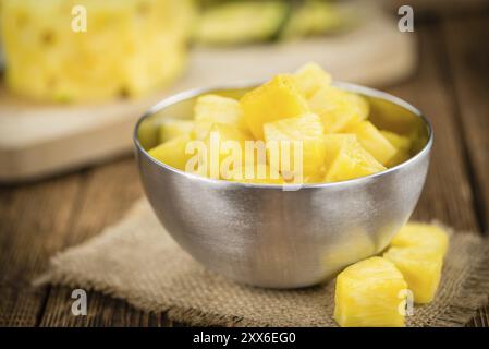 Sliced Pineapple on an old wooden table as detailed close-up shot, selective focus Stock Photo