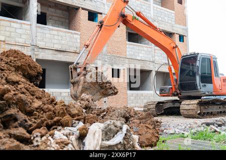 Excavator is digging the ground to embed septic tank in building site Stock Photo