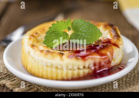 Mini Cheesecake (with Sauce) as high detailed close-up shot on a vintage wooden table (selective focus) Stock Photo