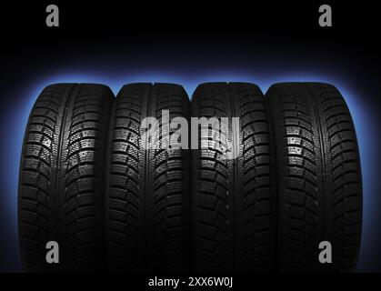 Set of four winter tires isolated on blue black background with clipping path Stock Photo