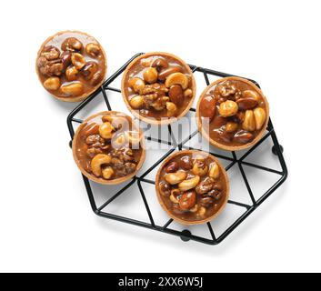 Tasty tarts with nuts and caramel on stand against white background Stock Photo