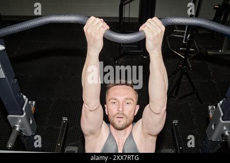 High angle shot of tired man doing pull-ups to develop muscles Stock Photo