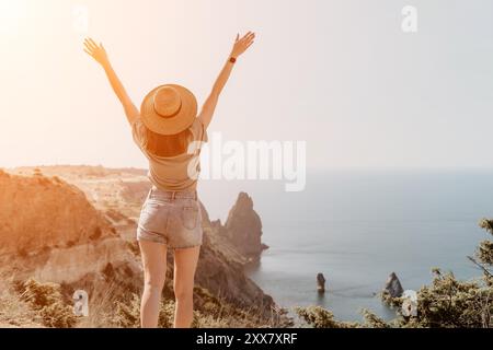 Woman Celebrating Freedom on Clifftop Overlooking Sea Stock Photo