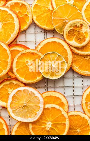 Dehydrated citrus slices arranged closely on a wire rack rack, . Stock Photo
