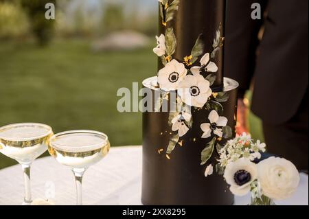 Close up photo of black wedding cake decorated with white anemones Stock Photo
