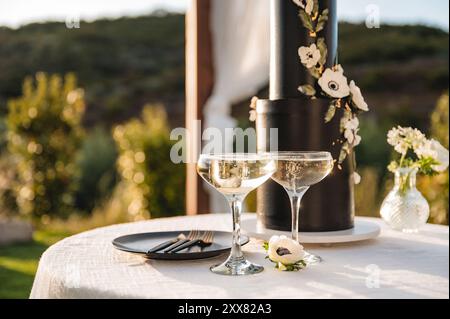 Champagne cups with dramatic wedding cake in background Stock Photo