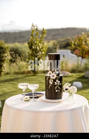 Table with Black wedding cake and two glasses of champagne Stock Photo