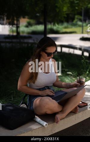 Woman working outside using laptop. Stock Photo