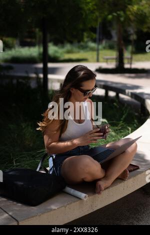 Woman working on laptop outside. Stock Photo