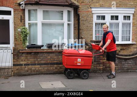 CROYDON, UK - JULY 8, 2024: Royal Mail hand cart postman delivering mail in Croydon, UK. Stock Photo