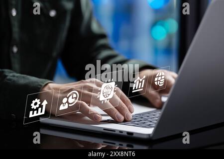 The businessman works at his laptop, where a holographic table appears displaying a graph with numerical data. Using a stylus, he interacts with the t Stock Photo