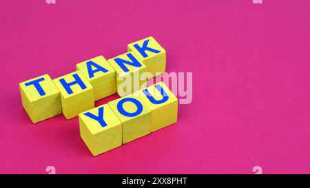 Thank you word above wooden cubes style and viola background con focus on first floor and copy space. Stock Photo