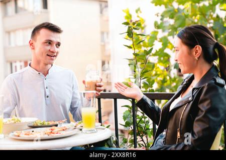 Happy young couple having lunch at outdoors restaurant Stock Photo