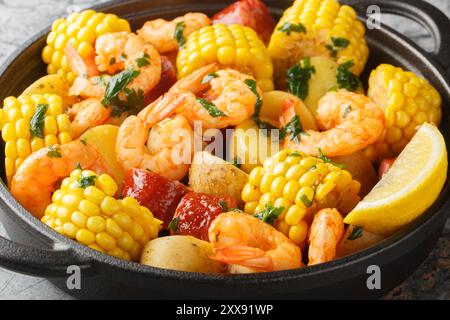 Old Bay Shrimp Boil with baby potatoes, flavorful sausage, and sweet corn all boiled together in one big pot closeup on the table. Horizontal Stock Photo