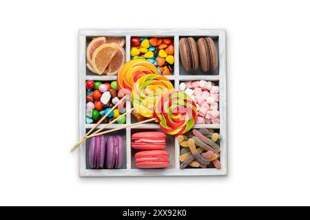 Various colorful candies, lollipops, and macaroons. Flat lay sweets in box. Isolated on white background Stock Photo