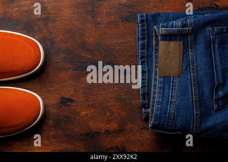 Men's Clothing on Wooden Background: Jeans, Sneakers, Flat Lay with Copy Space Stock Photo