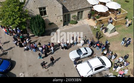 People queuing outside at the opening of Jeremy Clarkson's new pub, The Farmer's Dog, in Asthall, near Burford in Oxfordshire. Picture date: Friday August 23, 2024. Stock Photo