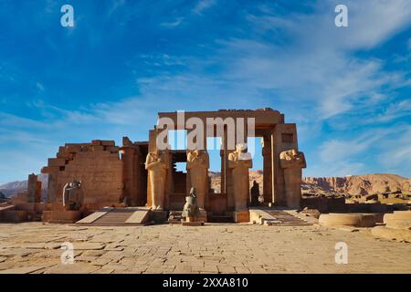 Entrance to the Hypostyle gallery of the Ramesseum, the Mortuary Temple of Pharoah Ramesses II the Great with his statues adorning the main columns a bright afternoon with blue skies at Luxor, Egypt Stock Photo