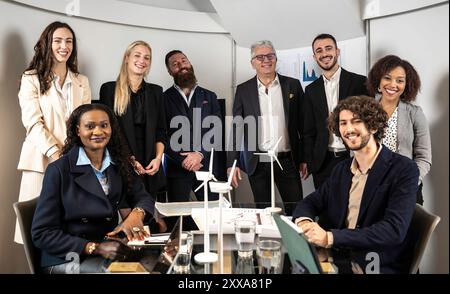 Diverse business team smiling confidently during a meeting focused on renewable energy solutions. Teamwork, sustainability, and corporate success. Stock Photo