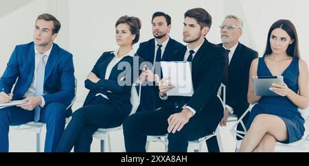 Confident young managers making notes during lecture Stock Photo