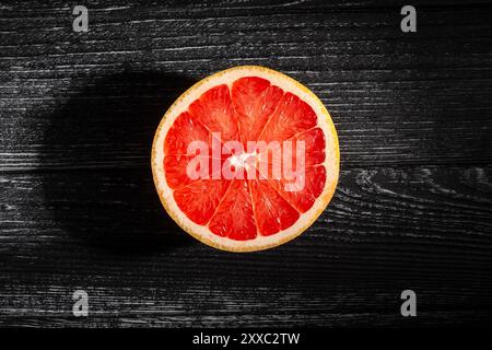 sliced grapefruit on black wood background top view Stock Photo
