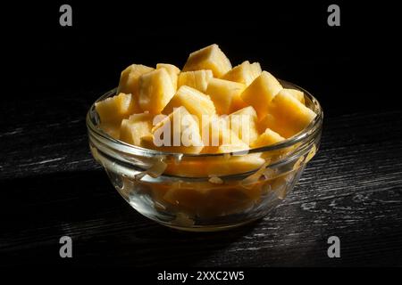 sliced pineapple bowl on black wood background Stock Photo