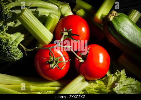 tomato branch sliced celery sticks on black background Stock Photo