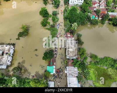 Dhaka, Bangladesh. 23rd Aug, 2024. An aerial view shows Volunteers rescue flood-affected residents in the Mohipal, area of Feni district in Chittagong division, Bangladesh, on August 23, 2024. At least 13 people are killed; a total of 43 upazilas in several districts are affected by the flash floods, and about 189,663 families are marooned. Credit: SOPA Images Limited/Alamy Live News Stock Photo