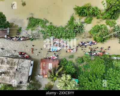 Dhaka, Bangladesh. 23rd Aug, 2024. An aerial view shows Volunteers rescue flood-affected residents in the Mohipal, area of Feni district in Chittagong division, Bangladesh, on August 23, 2024. At least 13 people are killed; a total of 43 upazilas in several districts are affected by the flash floods, and about 189,663 families are marooned. Credit: SOPA Images Limited/Alamy Live News Stock Photo