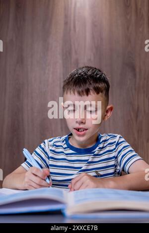 Boy is doing his homework in the kitchen. Stock Photo