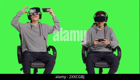 In studio, asian man enjoys phone game with virtual reality glasses, competing in online rpg using mobile vr software on headset. Young adult player enjoying good time with his friends. Stock Photo