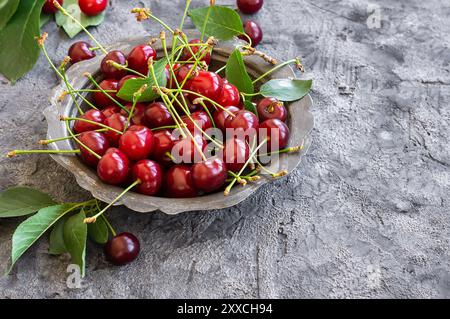 Fresh ripe sour cherry fruits in bowl on rustic table, red summer fruits Stock Photo