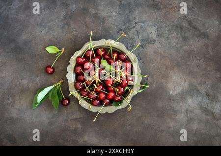 Fresh ripe sour cherry fruits in bowl on rustic table, red summer fruits Stock Photo