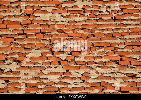 Backside of a brick wall. Uneven brick layout with mortar oozing out. Orange bricks weeping mortar. Stock Photo