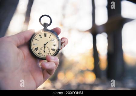 Hand held stop watch outdoors, autumn, blurry background Stock Photo