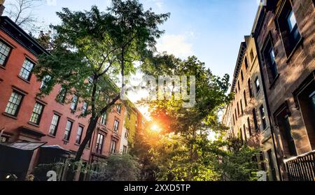 Tree lined block of historic apartment buildings on 10th Street in the Greenwich Village neighborhood of New York City NYC Stock Photo