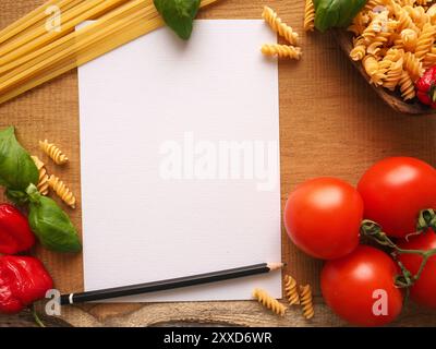 Pasta or Italian food concept background with an empty paper sheet and pencil on a wooden table Stock Photo