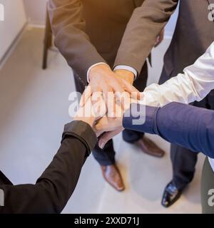 Close up businesspeople stacking hands meeting office Stock Photo