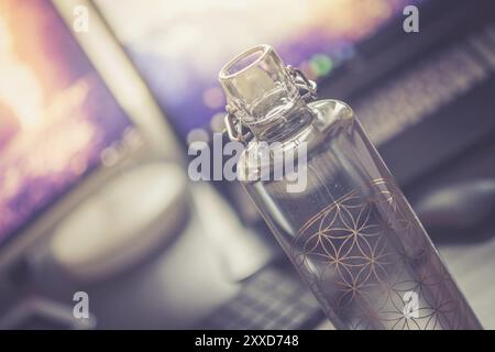 Close up of glass bottle in the office, drinking Stock Photo