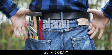 Close up picture of a craftsman with hammer, pencil and gripper in his pocket Stock Photo