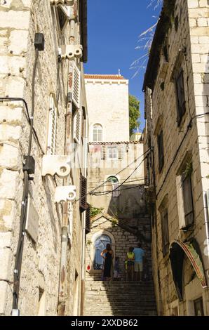 Croatia, 21 07 2014: Old town streets in town Sibenik with marble and stone buildings. People walking narrow path.Tourist place to visit, Europe Stock Photo