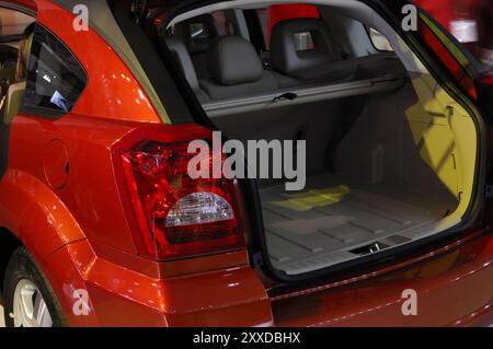 Stock photo of Red modern car back close-up with open trunk at a motor show Horizontal Stock Photo