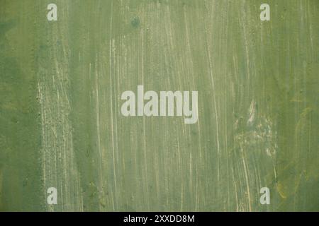 Textured metal surface carelessly colored green paint and faded in the sun in pale gray with rusty specks. An old grunge texture on a metal surface Stock Photo